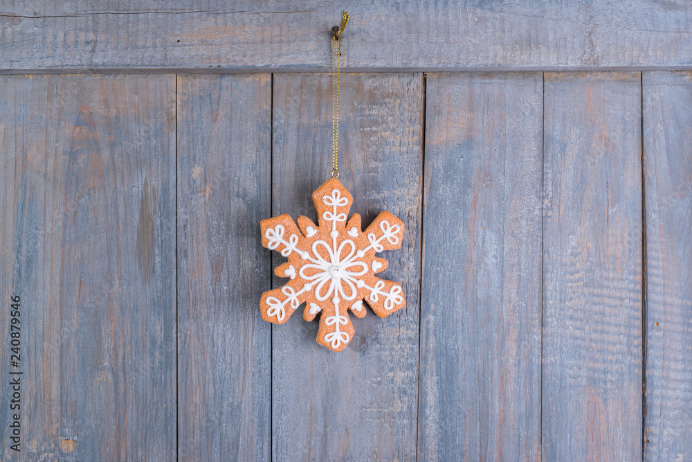 Gingerbread snowflakes cookies for Christmas hanging on wooden background. Gingerbread snowflakes cookies for Christmas hanging on wooden background.