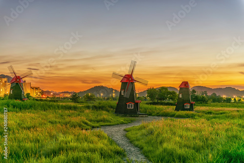 Fototapeta Naklejka Na Ścianę i Meble -  The sun rises in early morning windmill at Sora Ecological Wetland Park in Seoul, South Korea