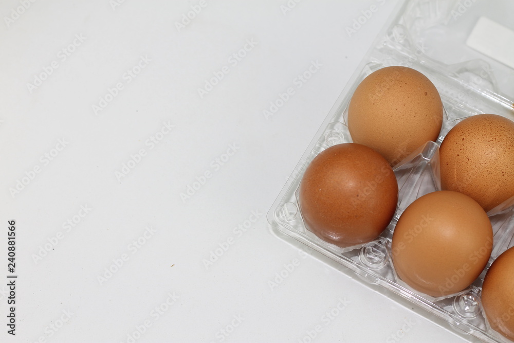 Close-up view of raw chicken eggs in egg box on white white background Close-up view of raw chicken eggs in egg box on white white background