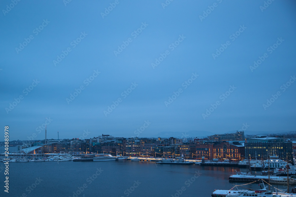 Oslo Norway coast during winter with a large number of docked boats in the center of the city covered with snow