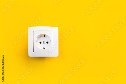 Foto white electrical outlet on isolated yellow background