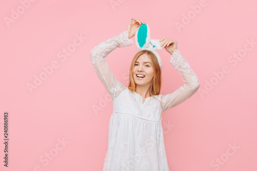 Beautiful young woman with Easter bunny ears, over pink background. Valentine's Day Concept