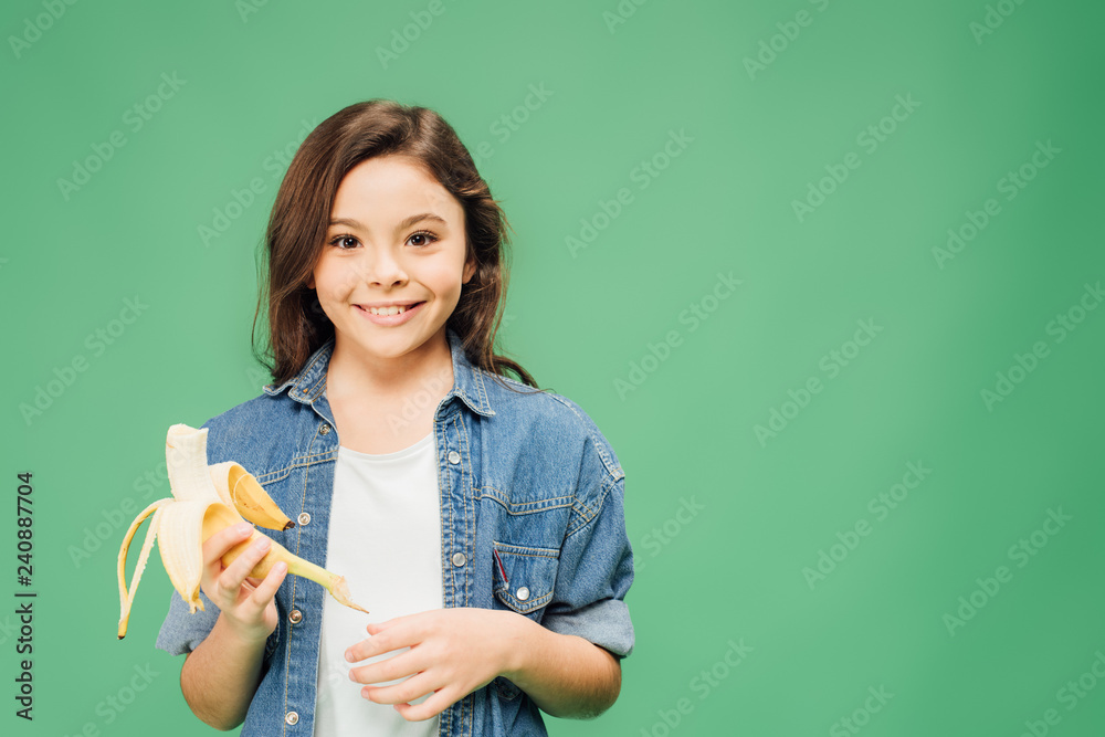 smiling child holding banana isolated on green smiling child holding banana isolated on green