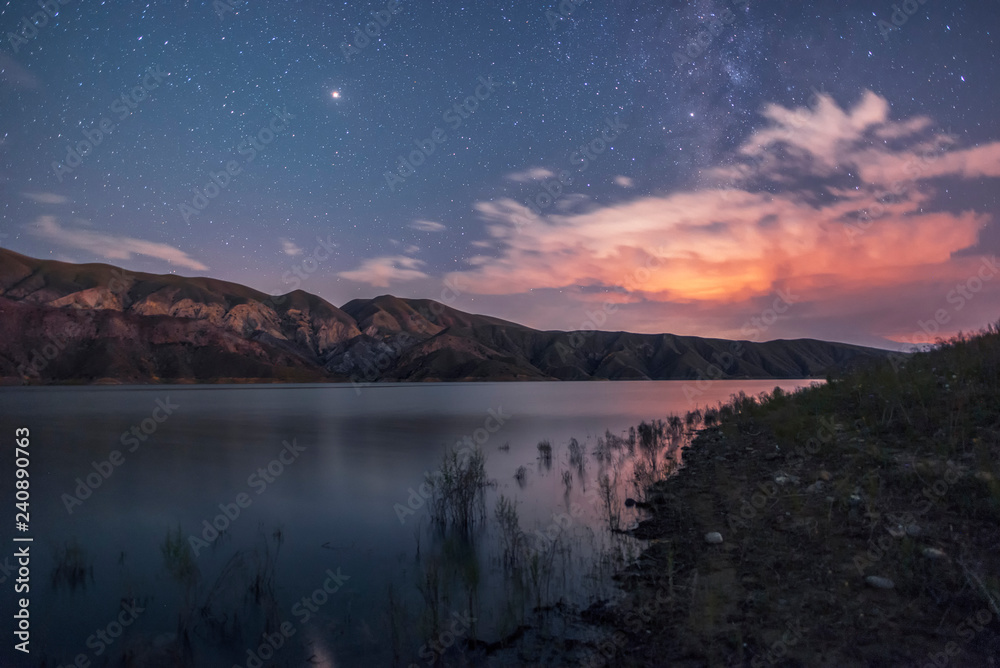 Mountains and lake in the starry night. Beautiful night landscape..