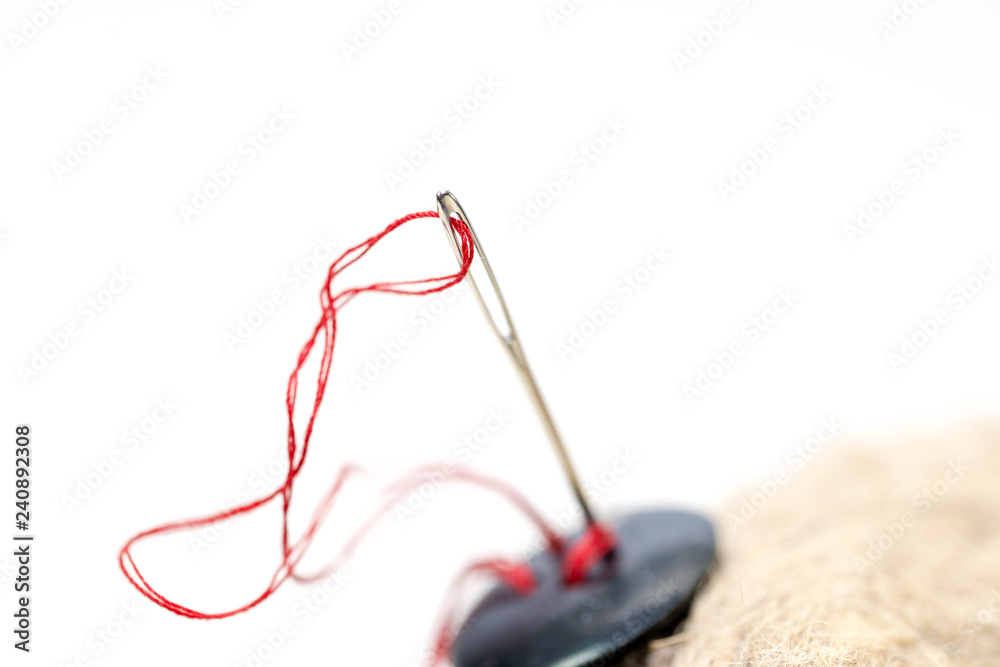 Needle eye with red thread , black button on hemp rope close up macro shot. Needle eye with red thread , black button on hemp rope close up macro shot.