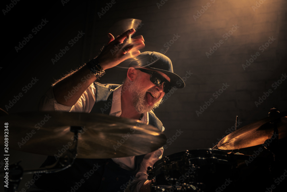 The drummer, vigorously playing the drums