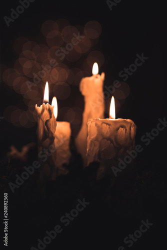 Christmas candles and ornaments over background with lights