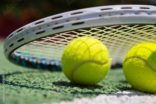 Tennis balls and racket on green tennis hard court © Sergey Kelin