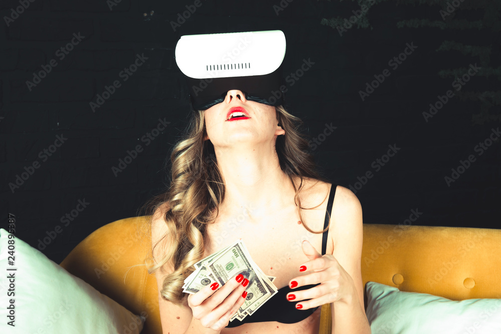 Månenytår Danser lejr Beautiful young girl with a perfect body with a VR headset is lying with a  bundle of dollar bills. Naked lady in expensive lingerie. Concept of  mindless spending money online stores Stock