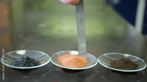 Physics of magnetic and nonmagnetic metals. Magent moving over nonmagnetic and magnetic metals in a laboratory setting.  photo