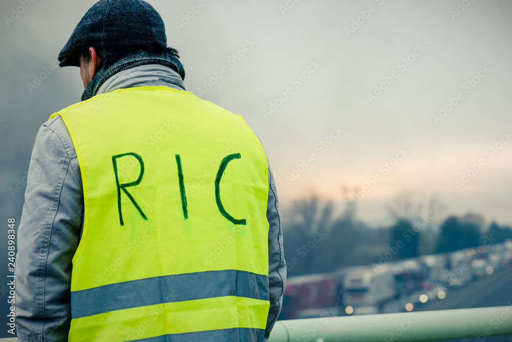 gilet jaune de dos avec inscription RIC - au loin l'autoroute est bloqué gilet jaune de dos avec inscription RIC - au loin l'autoroute est bloqué