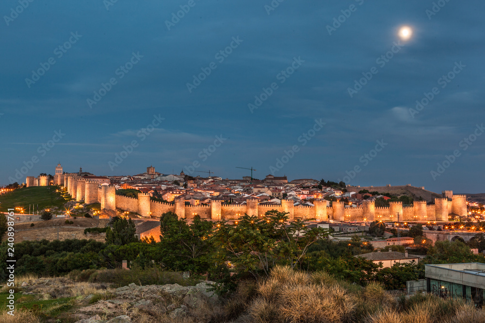 Night view of Ávila city & Walls of Ávila from the Calvary of Los Cuatro Postes viewpoint. Castilla Leon, Spain.