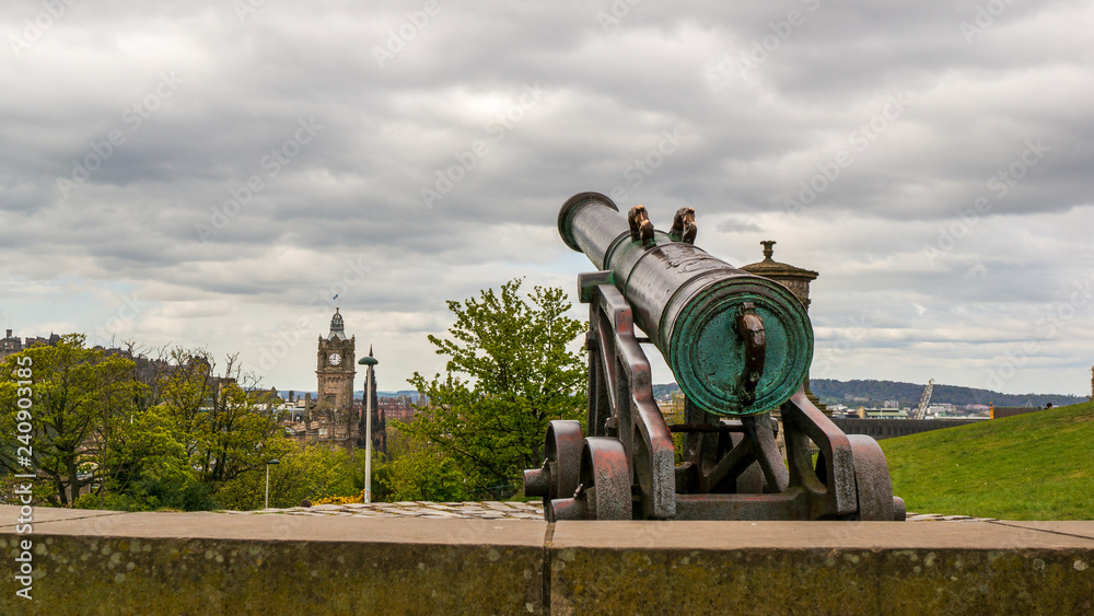 Closeup of The Portuguese Cannon on Calton Hill in Edinburgh, Scotland, pointing towards a distant tower clock. Closeup of The Portuguese Cannon on Calton Hill in Edinburgh, Scotland, pointing towards a distant tower clock.