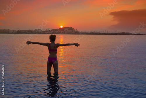 Girl silhouette at beach sunset open arms