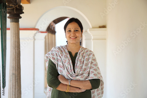 Canvas Print Cheerful indian woman standing infront of house