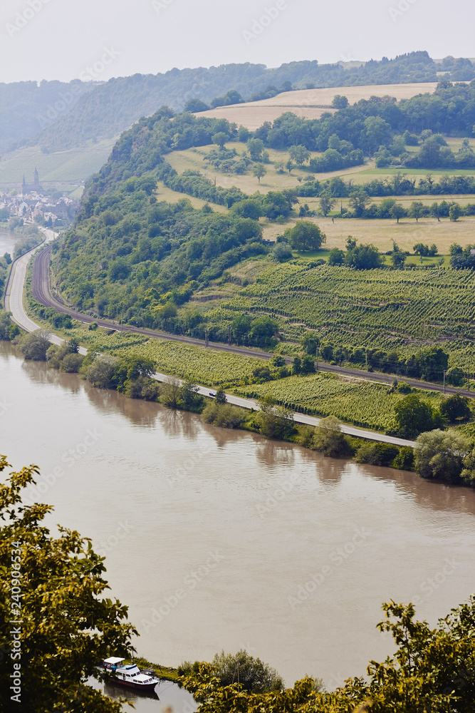 Panaramic view from above to the Mosel river and hills covered with trees and vineyards