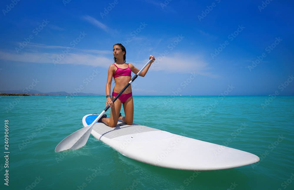 Girl rowing on knees on paddle surf SUP Girl rowing on knees on paddle surf SUP