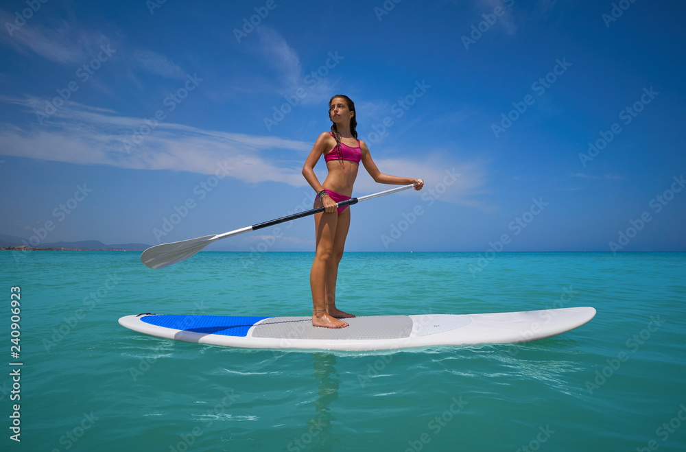 Girl standing on paddle surf board SUP Girl standing on paddle surf board SUP