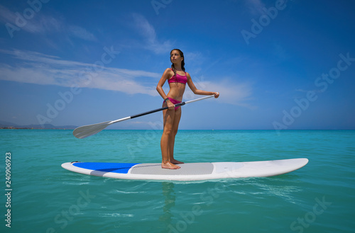Girl standing on paddle surf board SUP