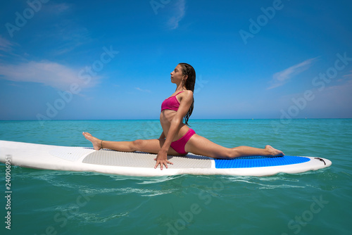 Girl gymnastics on paddle surf board SUP