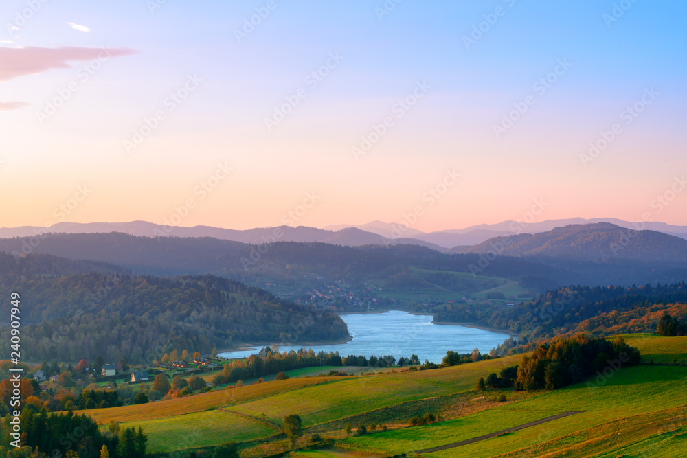Fototapeta premium Polanczyk, Bieszczady Mountains, Poland: Sun rising over mountains. Views from near hill. In background Solina Lake.