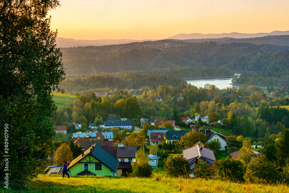 Fototapeta premium Polanczyk, Bieszczady Mountains, Poland: Sun rising over Polanczyk resort. Views from near hill. In background Solina Lake.
