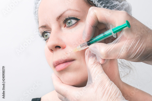 Women getting cosmetic injection into the face. Beauty injections, mesotherapy, revitalization, cosmetic medicine injection - the concept of rejuvenation. Isolated white space.