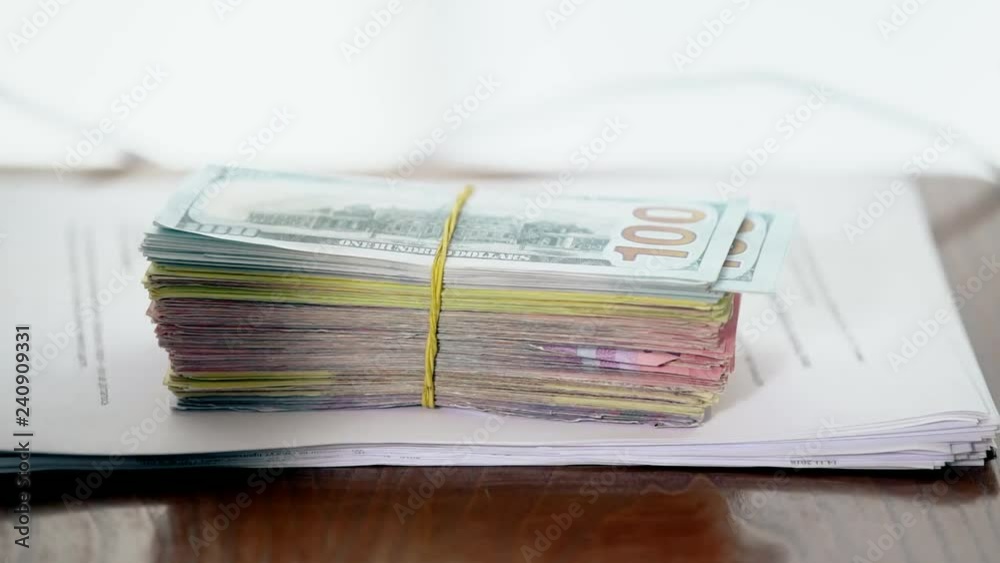 A bundle of money on the table, a lot of dollars in their hands, business people, net earnings, hit the bank, large bills, project fees, rich and successful businessmen A bundle of money on the table, a lot of dollars in their hands, business people, net earnings, hit the bank, large bills, project fees, rich and successful businessmen