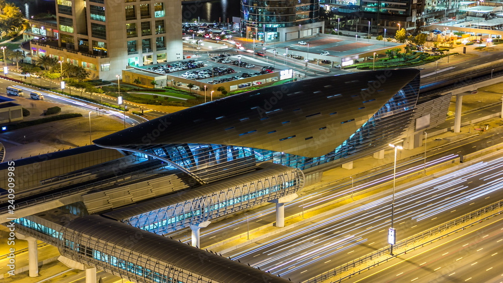 Metro station near Buildings of Jumeirah Lakes Towers with traffic on the road night timelapse. Metro station near Buildings of Jumeirah Lakes Towers with traffic on the road night timelapse.