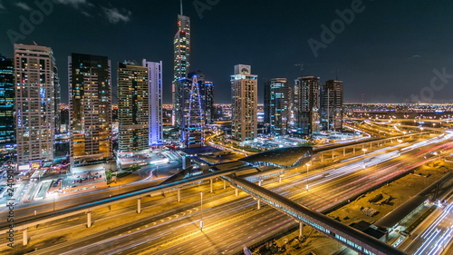 Buildings of Jumeirah Lakes Towers with traffic on the road night timelapse.