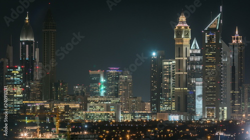 Scenic Dubai downtown skyline timelapse at night. Rooftop view of Sheikh Zayed road with numerous illuminated towers.