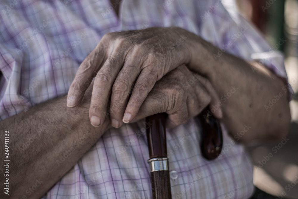 Detalle de las manos con un abuelo de 100 años  con un bastón