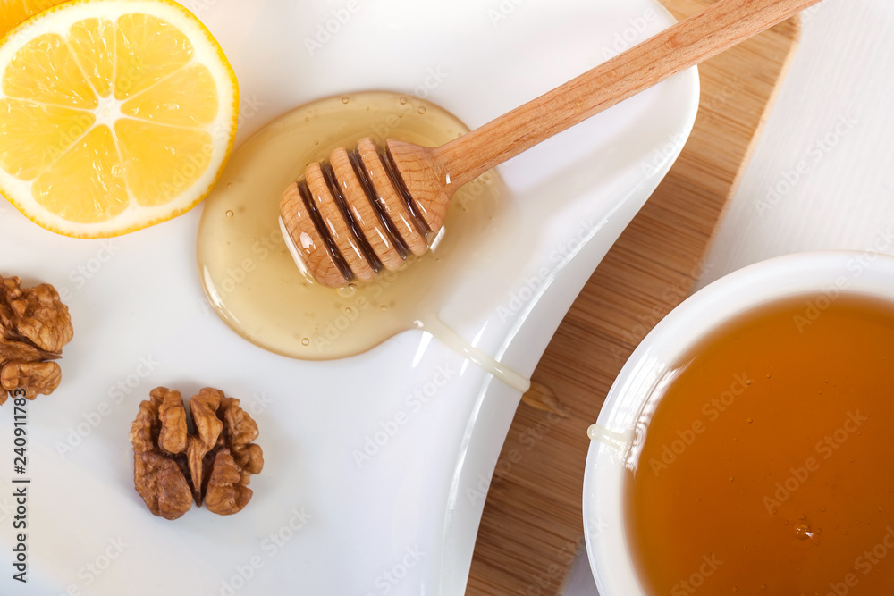 honey in a white ceramic bowl with honey dipper and lemon on a wooden kitchen boar honey in a white ceramic bowl with honey dipper and lemon on a wooden kitchen boar