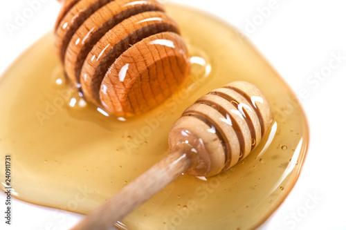 Honey with wooden dipper isolated on white background