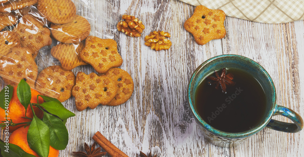 ceramic Cup of black tea with a handful of cookies with nuts on a white, old, shabby wooden table, vertical view. the composition of the morning Breakfast with cookies.