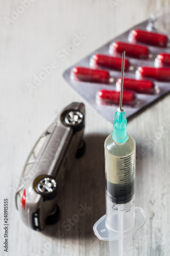 Driving under the influence of drugs. Pills, syringe and overturned car