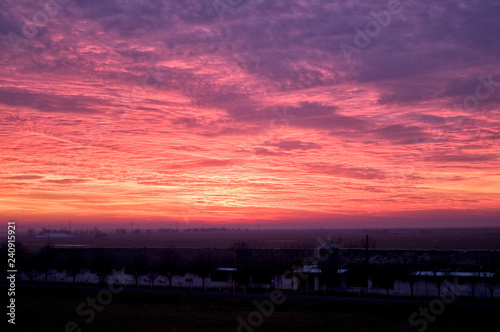 A dramatic purple pink and orange sunset with wispy clouds.