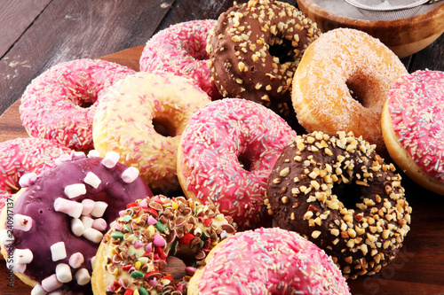 assorted donuts with chocolate frosted, pink glazed and sprinkles donuts