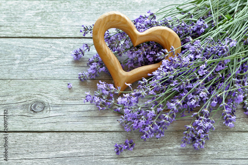Lavender flowers  with heart 
on wooden background 