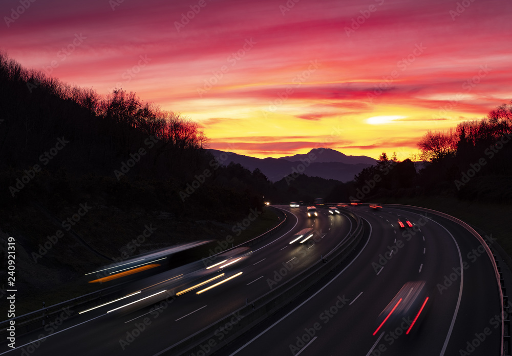 Car lights at sunset driving at high speed on the highway, San Sebastian, Euskadi Car lights at sunset driving at high speed on the highway, San Sebastian, Euskadi