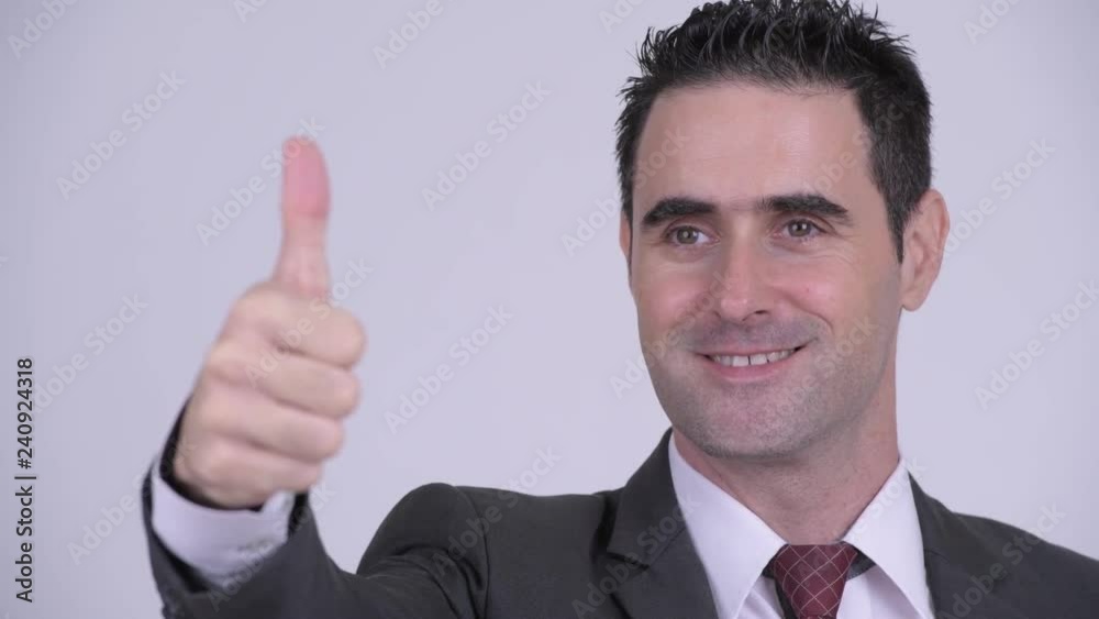 Face of happy handsome businessman thinking while giving thumbs up Face of happy handsome businessman thinking while giving thumbs up