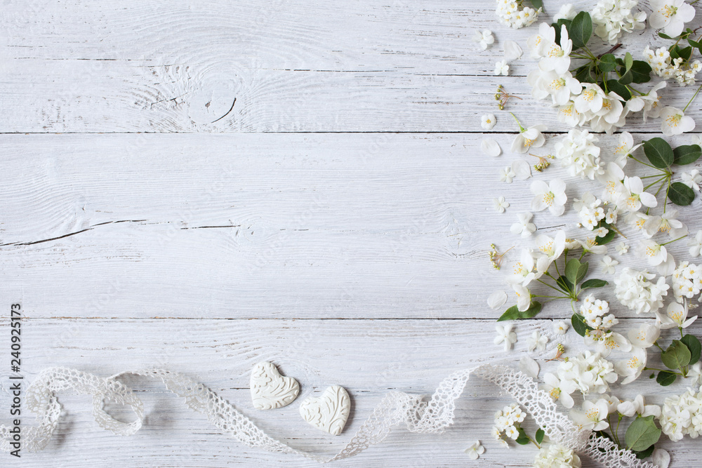 White wooden background with white spring flowers, hearts and lace ribbon - obrazy, fototapety, plakaty 
