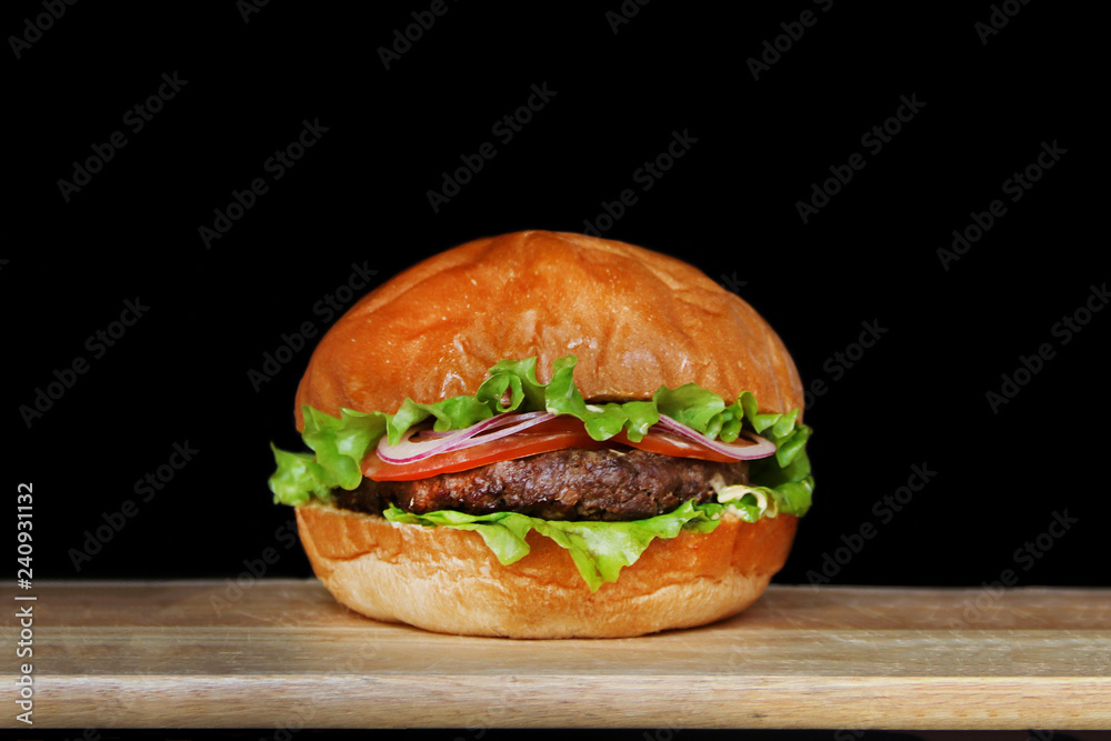 burger isolated on black background. delicious burger with beef, salad and tomatoes