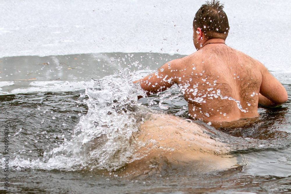 A man swimming in the lake in winter. Ice hole. Winter swimmer.