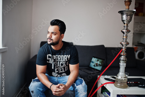 Casual beard indian man sitting at room against hookah. © AS Photo Family