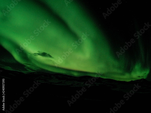 Winter scenic landscape night view of Aurora Borealis/Northern lights dancing on the clear sky full of stars above lake Myvatn, north Iceland Beautiful winter wonderland/fairytale background scene. 