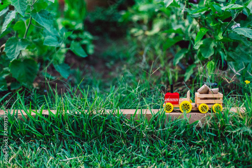 Wooden toy truck transporting packages through the lawn or nature  lots of empty space for text copy space.