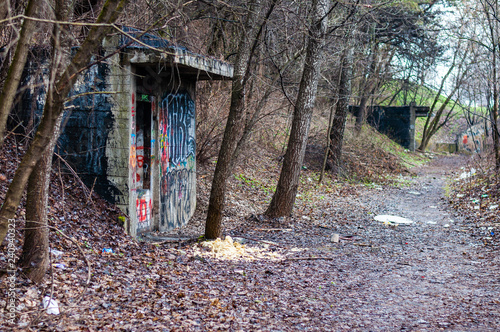 Entrance to abandoned concrete bunker built during the Second World War right in a hill near the center of Vilnius. Walls painted and decorated with graffiti photo