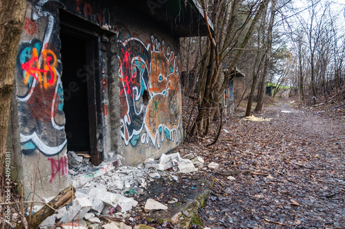 Entrance to abandoned concrete bunker built during the Second World War right in a hill near the center of Vilnius. Walls painted and decorated with graffiti photo