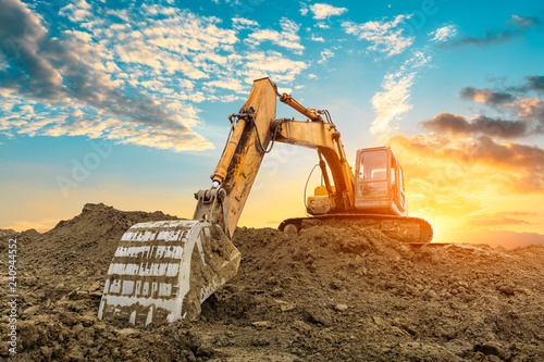 Excavator work on construction site at sunset